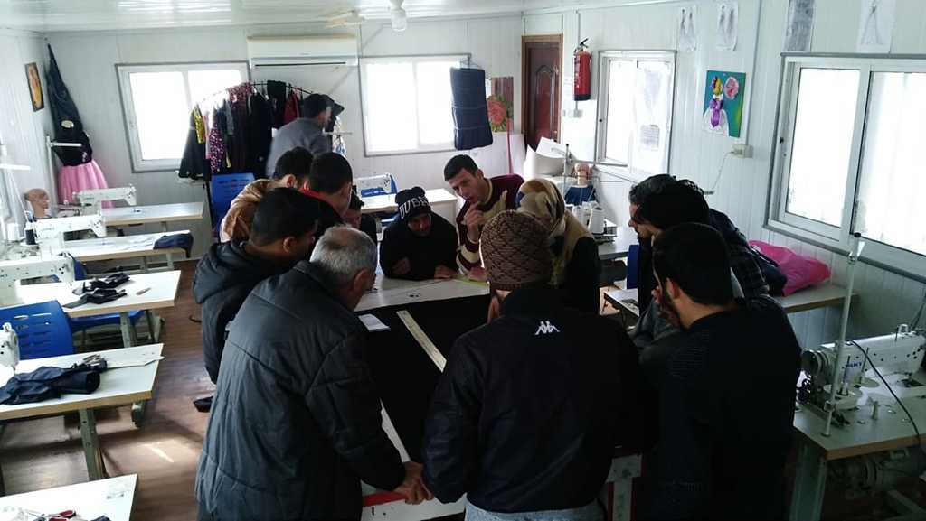 A men's sewing class in Za'atari funded by All We Can. 
