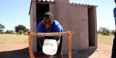 Glorious washes her hands using a tippy tap in Zimbabwe