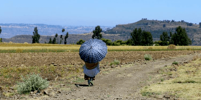 A woman shelters under an umbrella in Ethiopia.