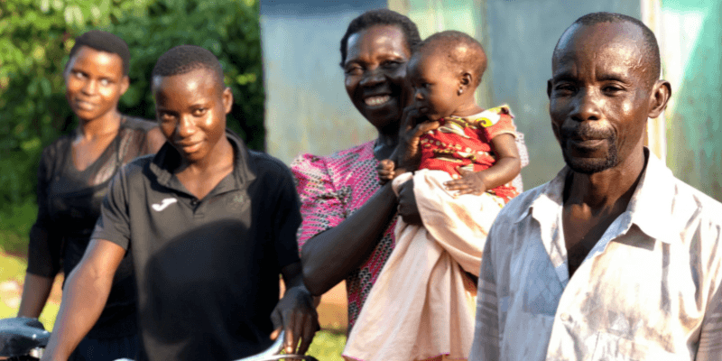 R-R: Harriet, Andrew, Florence (holding Mariam) and David stand outside their home in Butagaya.